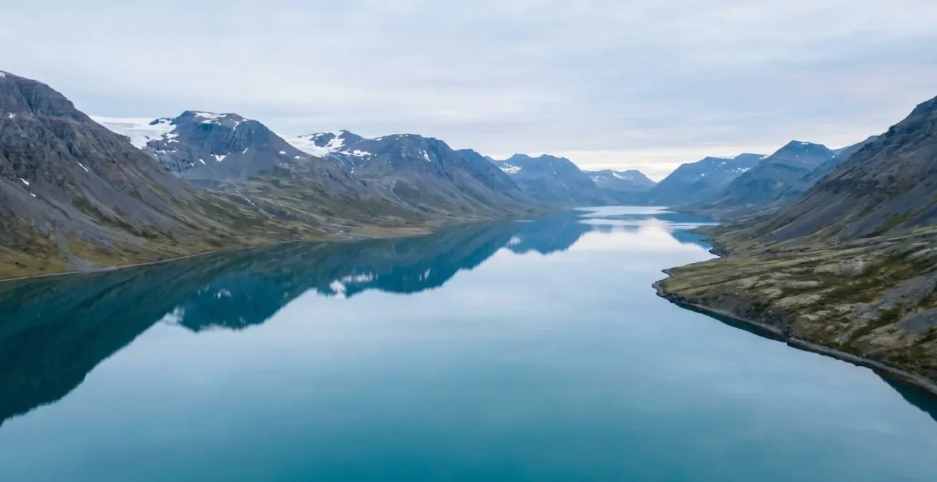 Vue panoramique d'un fjord islandais aux eaux calmes et protégées entouré de montagnes