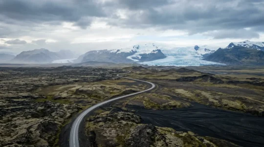 Paysage époustouflant d'Islande avec glaciers, volcans et routes sinueuses sous un ciel dramatique