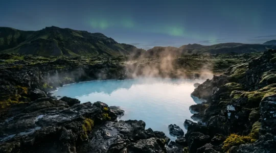 Bassin thermal naturel entouré de formations volcaniques islandaises sous un ciel crépusculaire