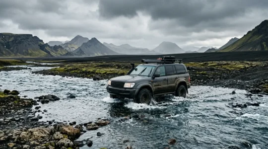Véhicule 4x4 traversant un gué dans les hautes terres d'Islande avec paysage volcanique