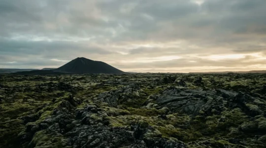 Paysage volcanique islandais avec formations de lave anciennes sous un ciel dramatique